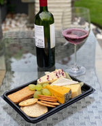 Set of 30 small black buffet platters with clear reusable and recyclable lids by Platterplus, ideal for food presentation.